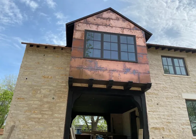Copper metal panel facade on a stone building for Skylight Installation in Crestwood